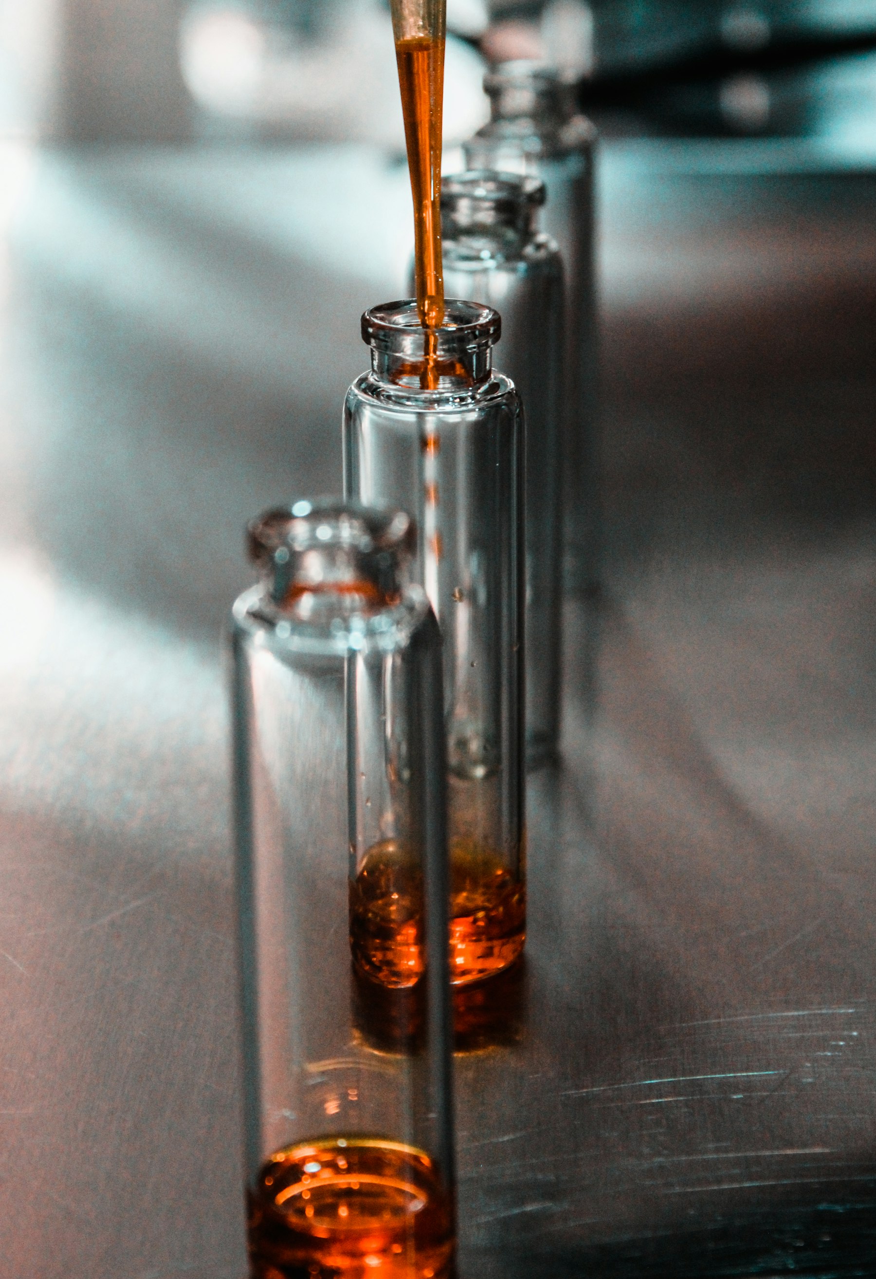 A glass sample vial holding amber solution, close up